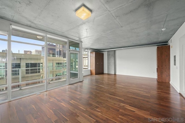 unfurnished room featuring a wall of windows and dark hardwood / wood-style floors