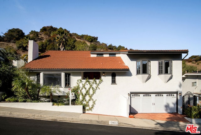 mediterranean / spanish-style home with a garage