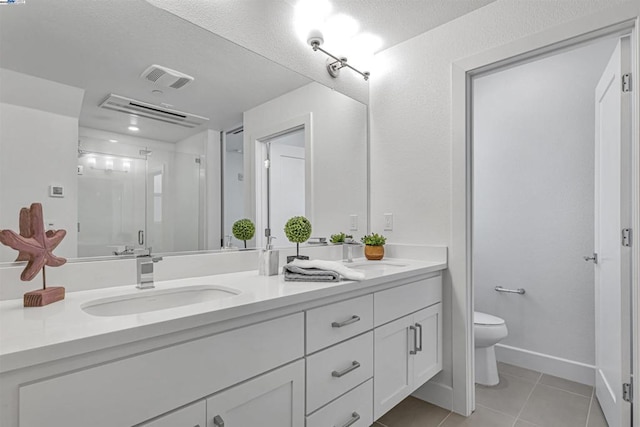 bathroom with an enclosed shower, vanity, tile patterned flooring, and toilet