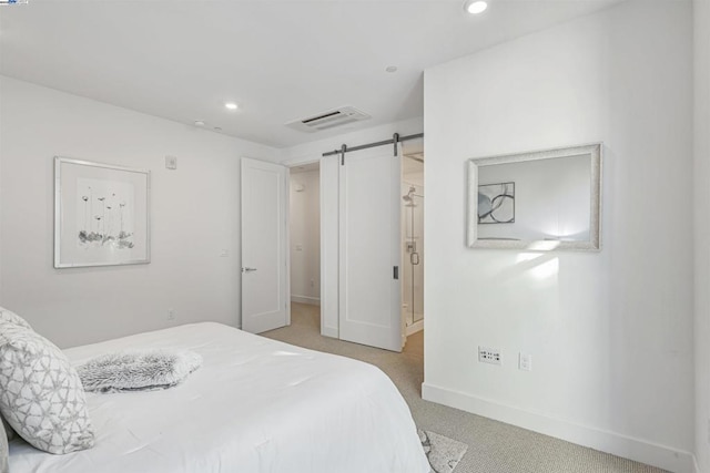 bedroom with a barn door and carpet floors