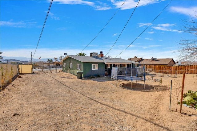 back of house featuring a mountain view and a trampoline