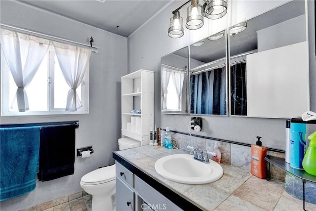 bathroom featuring vanity, toilet, a healthy amount of sunlight, and a shower with shower curtain