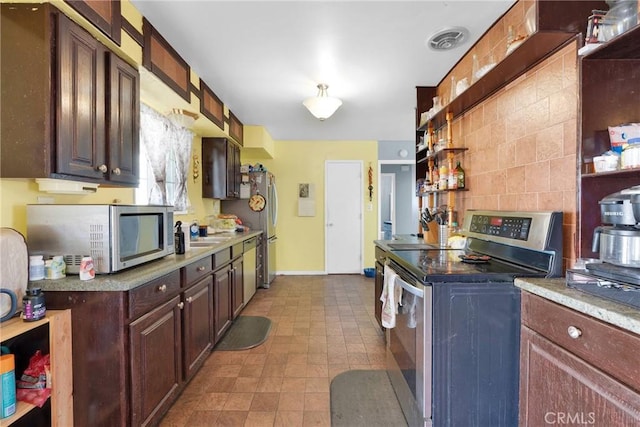 kitchen with stainless steel appliances, tasteful backsplash, sink, and dark brown cabinetry