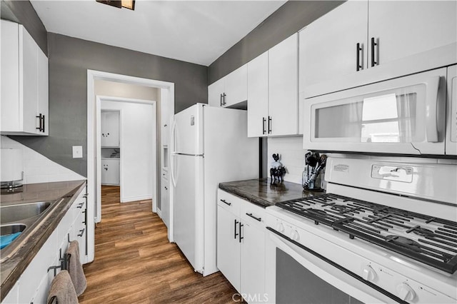 kitchen with dark hardwood / wood-style floors, backsplash, white cabinets, and white appliances