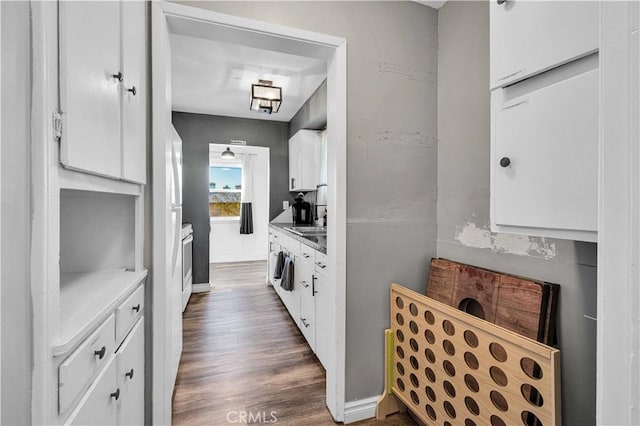 kitchen featuring dark hardwood / wood-style flooring, sink, and white cabinets