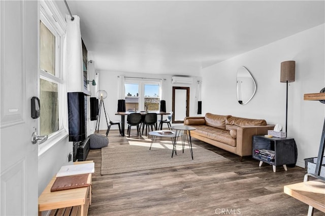 living room featuring dark hardwood / wood-style floors and a wall unit AC