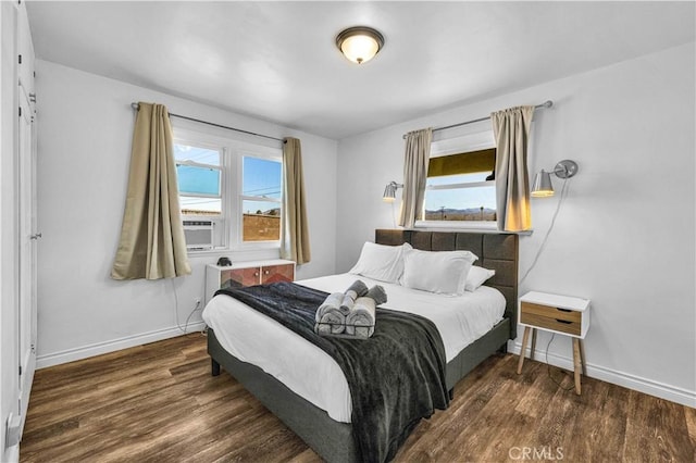 bedroom with cooling unit and dark hardwood / wood-style floors