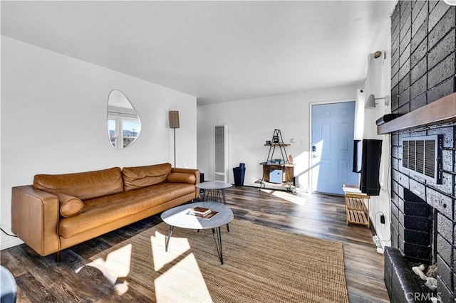 living room with dark wood-type flooring and a fireplace