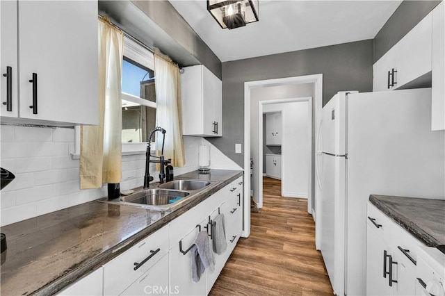 kitchen with white fridge, sink, white cabinets, and dark hardwood / wood-style flooring