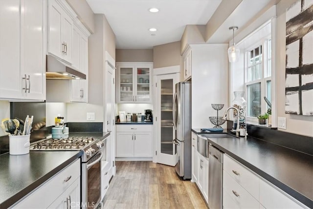 kitchen with appliances with stainless steel finishes, decorative light fixtures, sink, and white cabinets