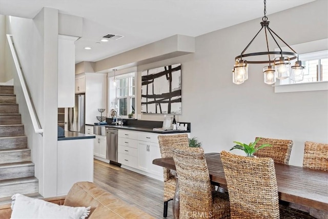 dining space featuring wood-type flooring and an inviting chandelier