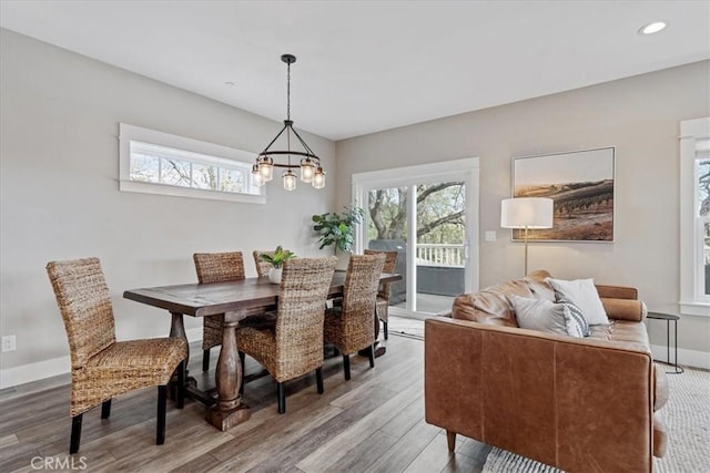 dining space featuring hardwood / wood-style flooring, a wealth of natural light, and a chandelier