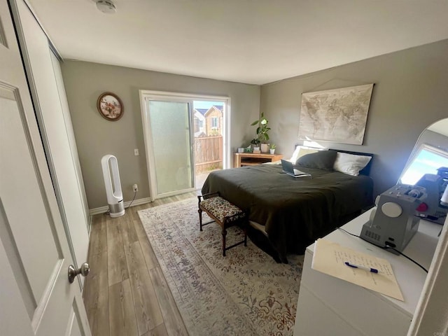 bedroom with access to exterior and light hardwood / wood-style floors