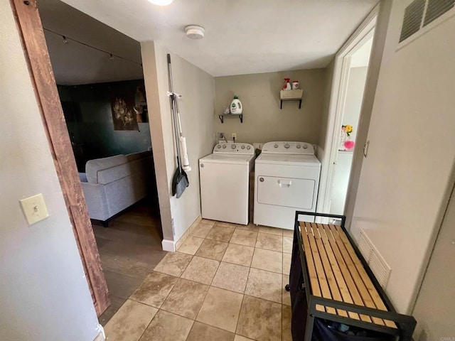 laundry area featuring light tile patterned flooring and washer and clothes dryer