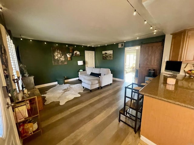 living room featuring hardwood / wood-style flooring, track lighting, and a barn door