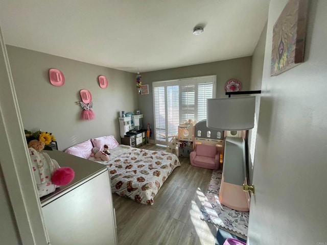 bedroom featuring hardwood / wood-style flooring and fridge