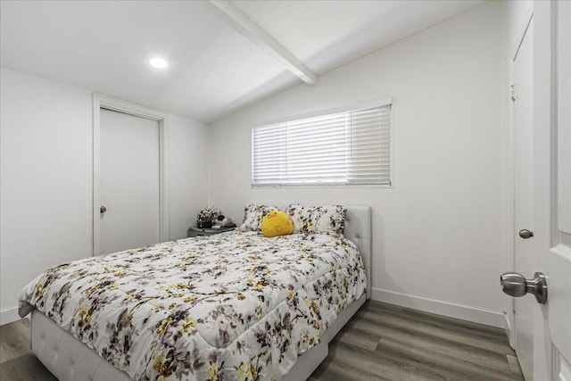 bedroom featuring lofted ceiling with beams, dark hardwood / wood-style flooring, and a closet