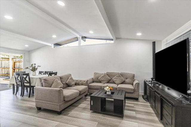 living room featuring vaulted ceiling with beams and light wood-type flooring