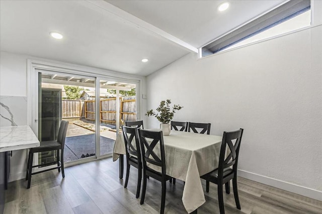 dining area featuring hardwood / wood-style flooring and beamed ceiling