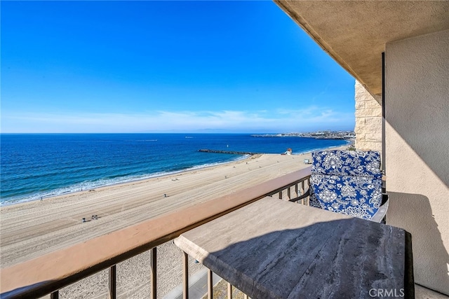 balcony featuring a water view and a beach view