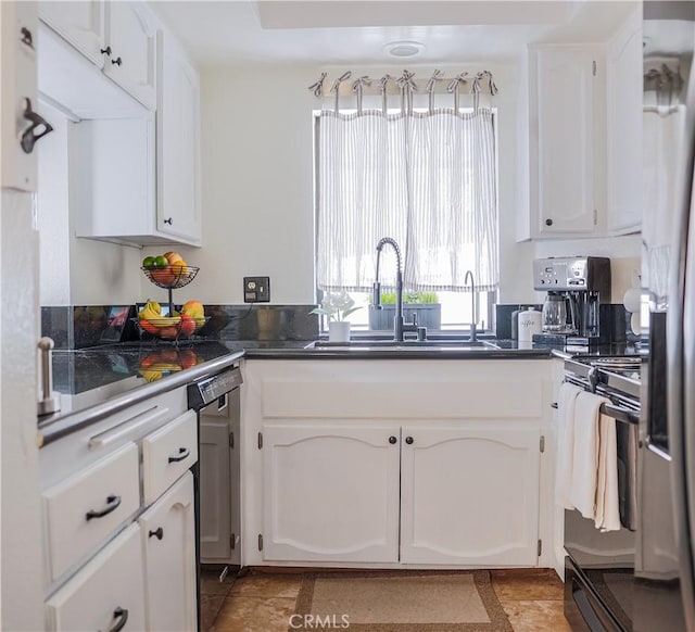 kitchen featuring dishwasher, stove, sink, and white cabinets