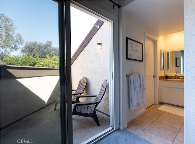 doorway with sink and light tile patterned floors