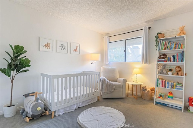 bedroom featuring a crib, a textured ceiling, and carpet