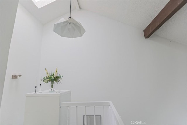 interior space with lofted ceiling with skylight and a textured ceiling