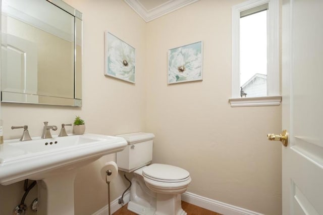 bathroom featuring ornamental molding, toilet, and sink