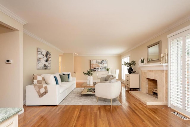 living room featuring a high end fireplace, a wealth of natural light, and light wood-type flooring