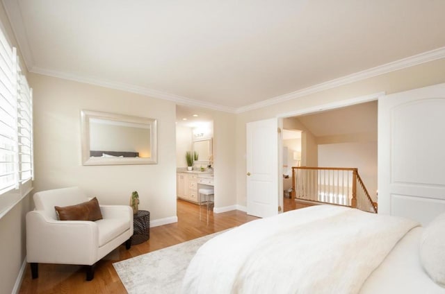 bedroom with crown molding, ensuite bathroom, and light hardwood / wood-style floors