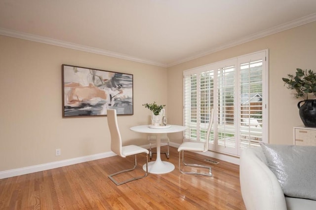 dining area featuring hardwood / wood-style flooring and ornamental molding