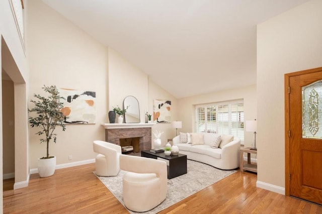 living room featuring high vaulted ceiling, a high end fireplace, and light wood-type flooring