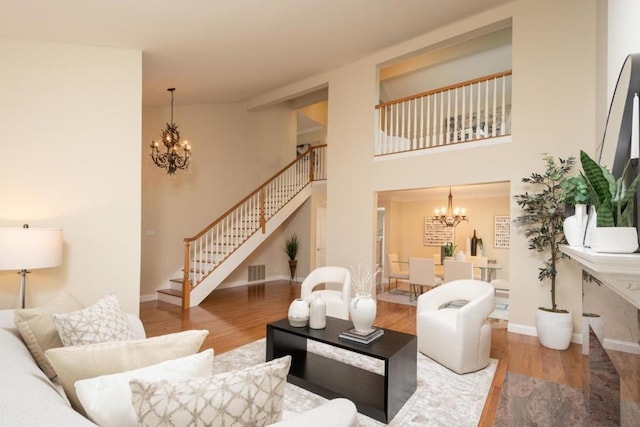 living room featuring hardwood / wood-style flooring, a high ceiling, and a chandelier