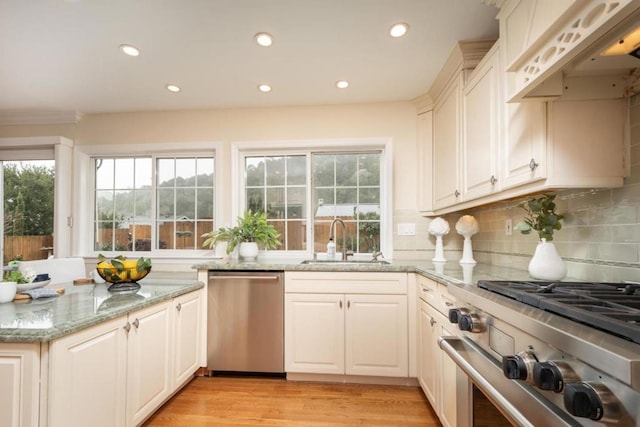 kitchen featuring light stone countertops, appliances with stainless steel finishes, sink, and plenty of natural light