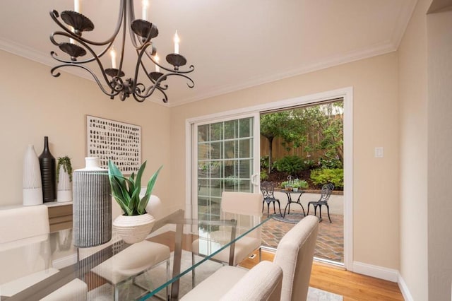 dining area featuring hardwood / wood-style flooring, crown molding, and a chandelier