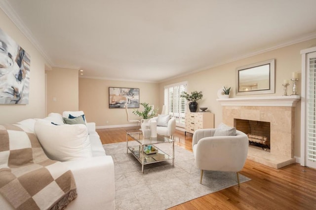 living room with hardwood / wood-style flooring, ornamental molding, and a premium fireplace