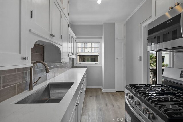 kitchen featuring white cabinetry, appliances with stainless steel finishes, sink, and decorative backsplash