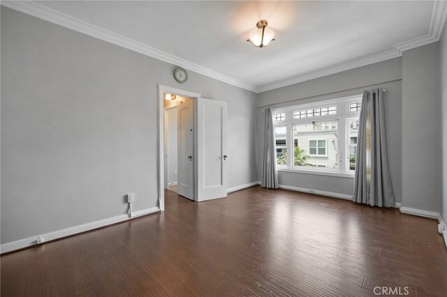 spare room featuring crown molding and dark hardwood / wood-style floors