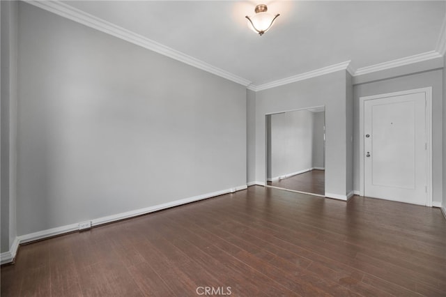 spare room with crown molding and dark wood-type flooring