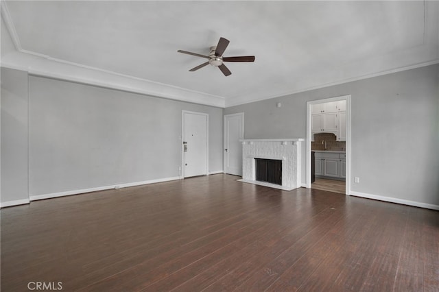 unfurnished living room with a fireplace, crown molding, dark wood-type flooring, and ceiling fan