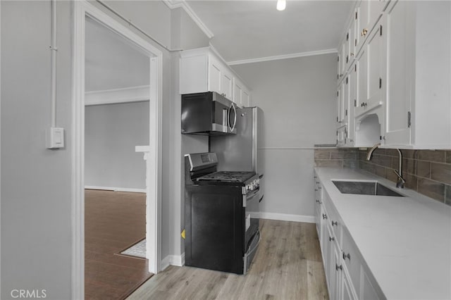 kitchen featuring sink, crown molding, white cabinetry, stainless steel appliances, and tasteful backsplash