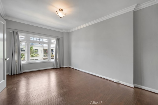 spare room with ornamental molding and dark hardwood / wood-style flooring