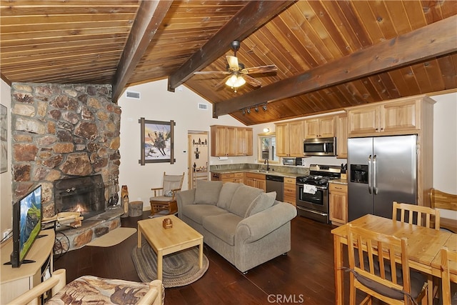 living room featuring dark hardwood / wood-style floors, a fireplace, lofted ceiling with beams, sink, and ceiling fan