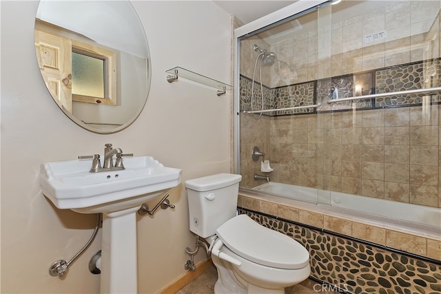 bathroom with shower / bath combination with glass door and toilet