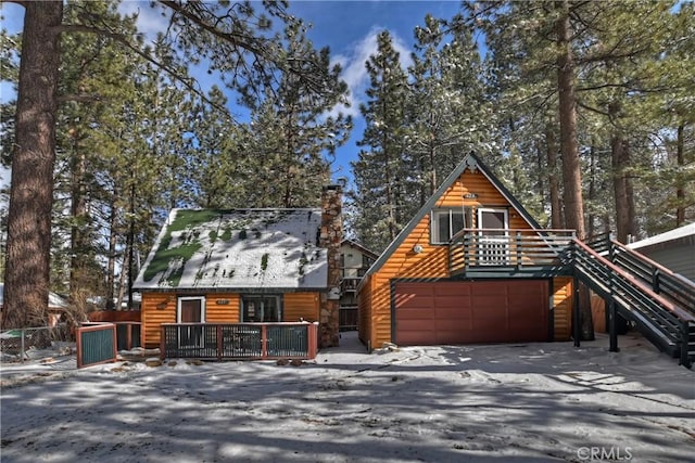 log-style house featuring a wooden deck