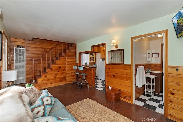 living room with dark hardwood / wood-style flooring and wood walls