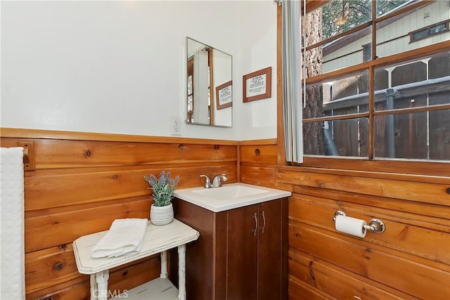 bathroom with vanity and wood walls