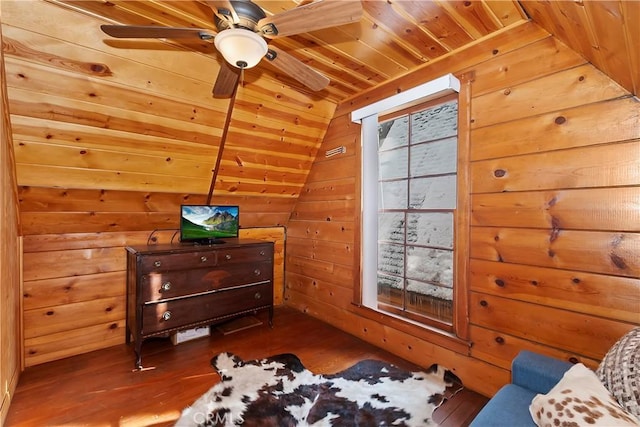 interior space featuring multiple windows, vaulted ceiling, wood ceiling, and wood walls