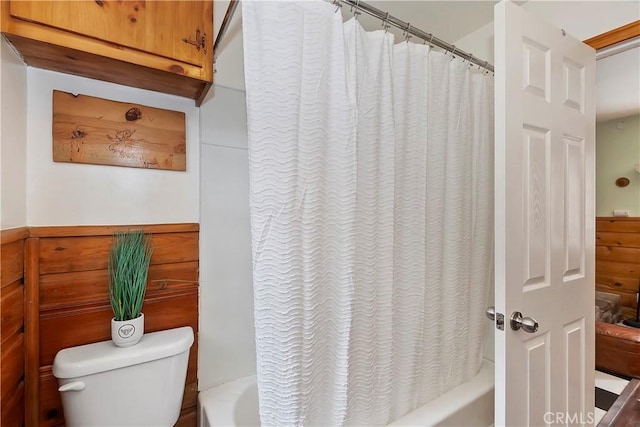 bathroom with shower / bath combination with curtain and toilet